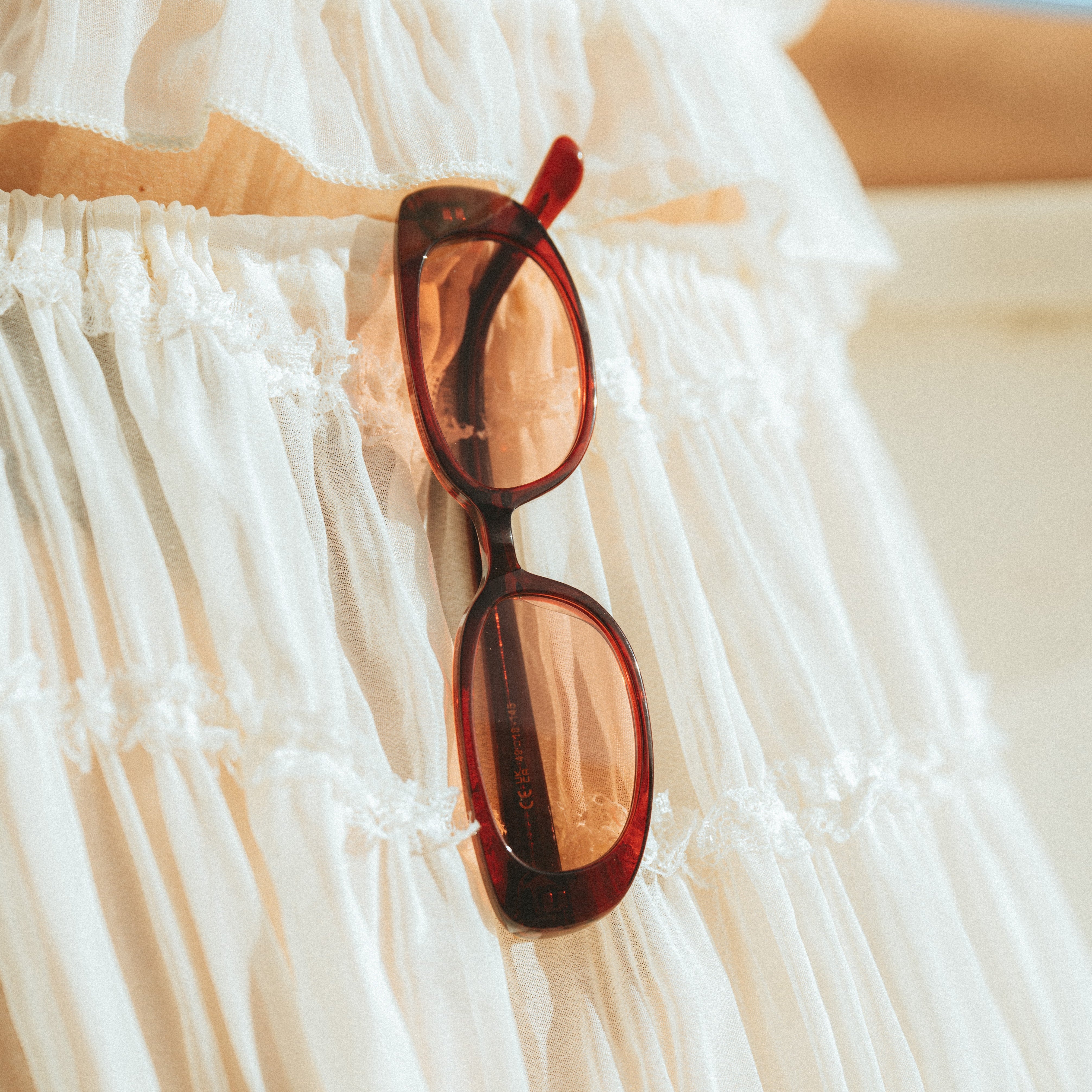 Closeup product shot of Isla Sunwear cherry red oval sunglasses, designed for smaller faces.