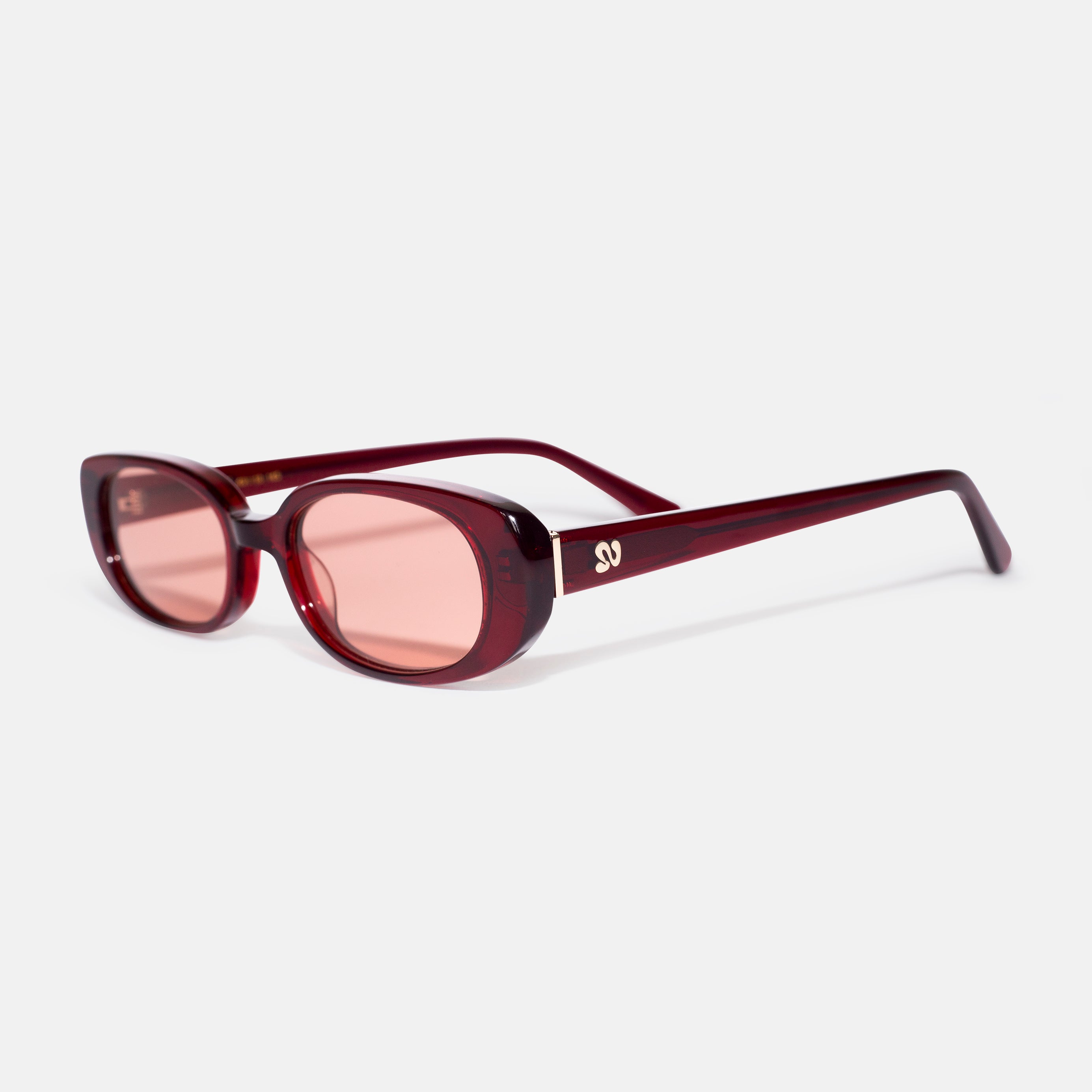 Side angle of cherry red oval sunglasses showing temple detail, designed for smaller faces by Isla Sunwear.