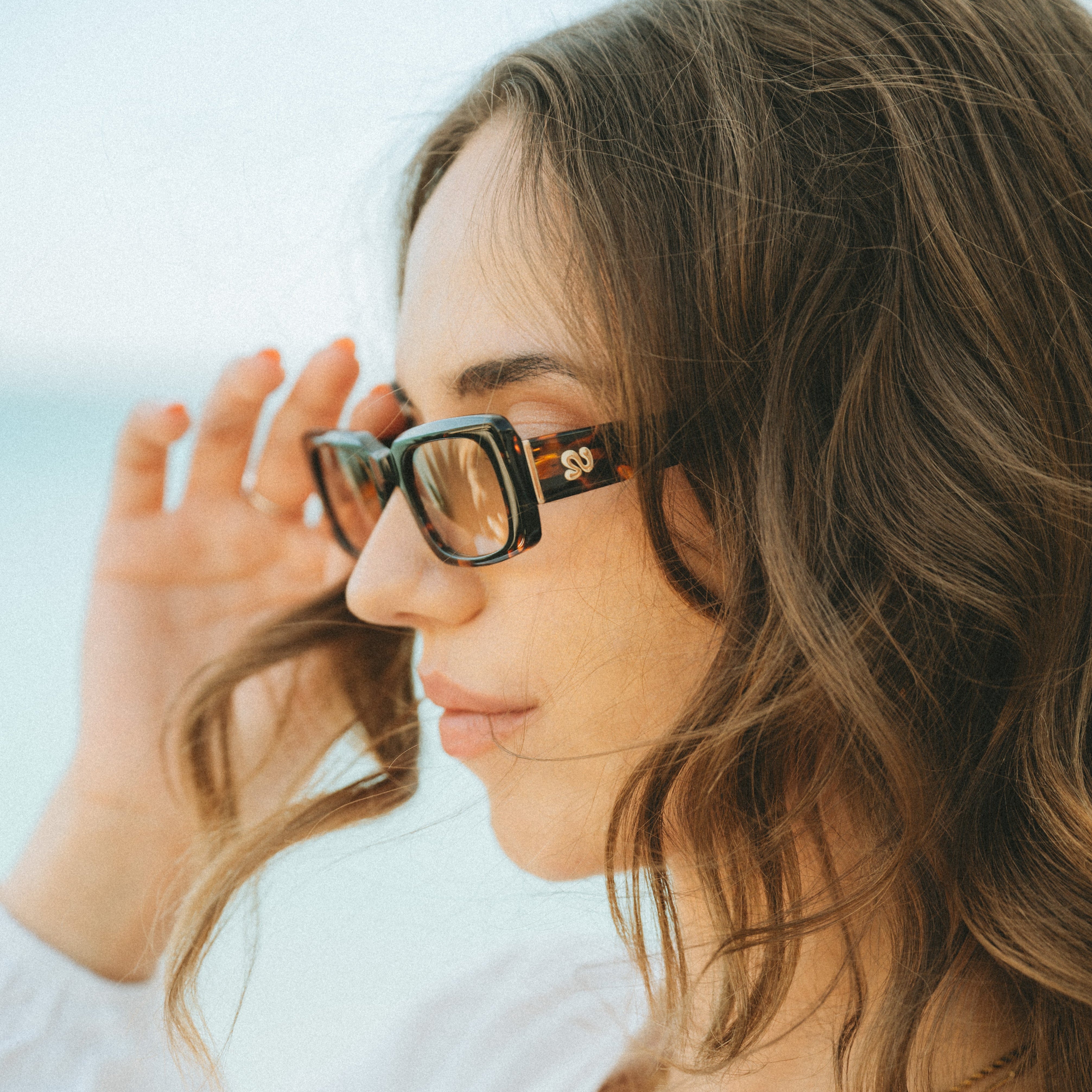 Closeup shot of a woman wearing Isla Sunwear tortoise rectangular sunglasses, designed for smaller faces.
