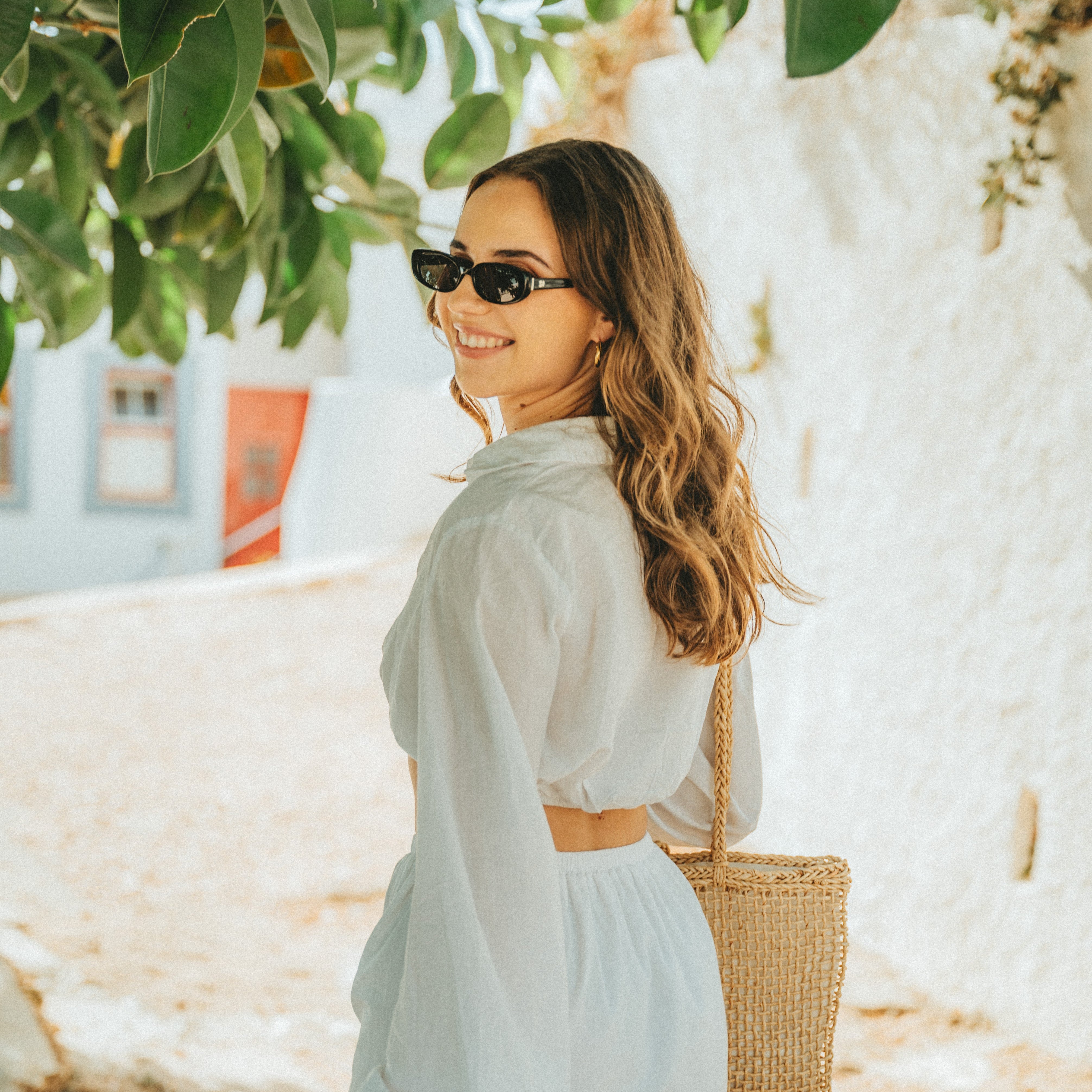 Portrait of a woman wearing Isla Sunwear black oval sunglasses, designed for smaller faces.