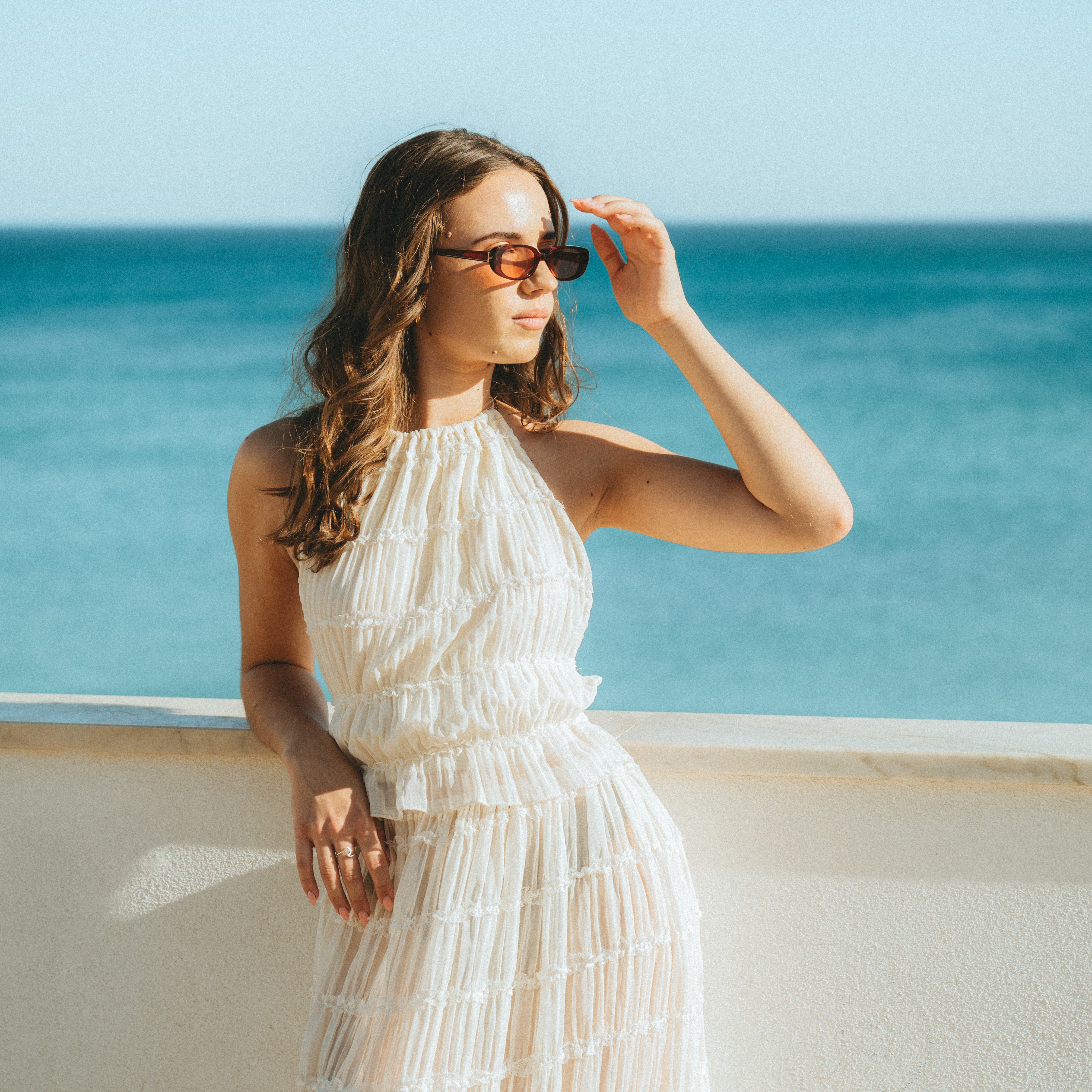 Portrait of a woman wearing Isla Sunwear cherry red oval sunglasses, designed for smaller faces.